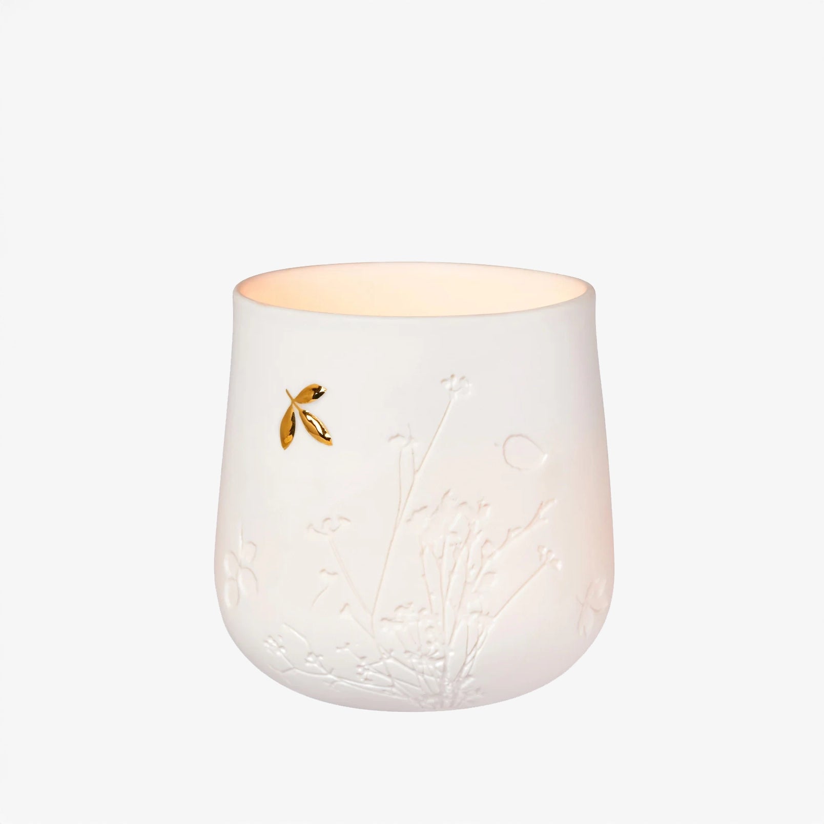 White ceramic candle holder with embossed design and gold dragonfly on a white background
