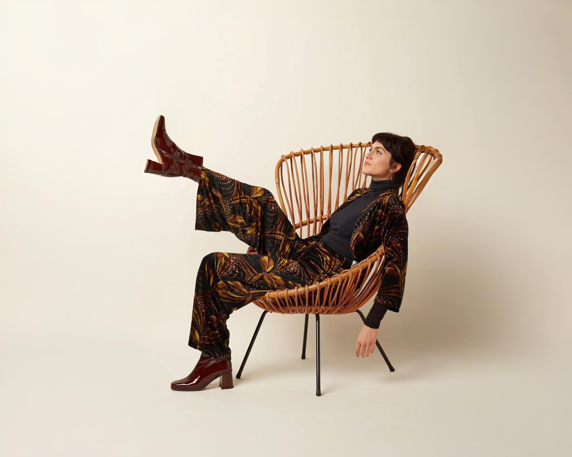 Woman sitting on a chair wearing a patterned pant suit