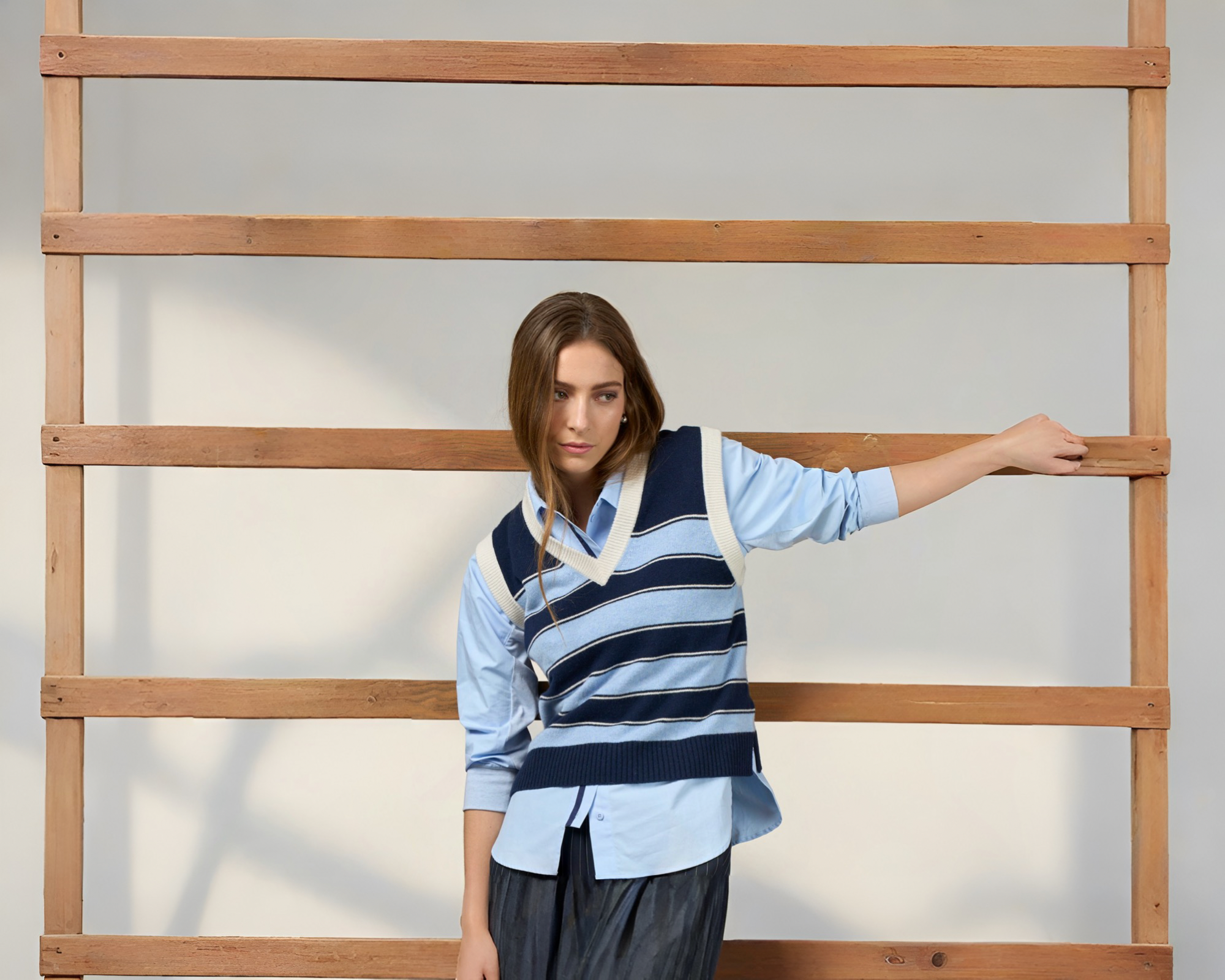 A woman wearing a blue shirt and blue stripe vest