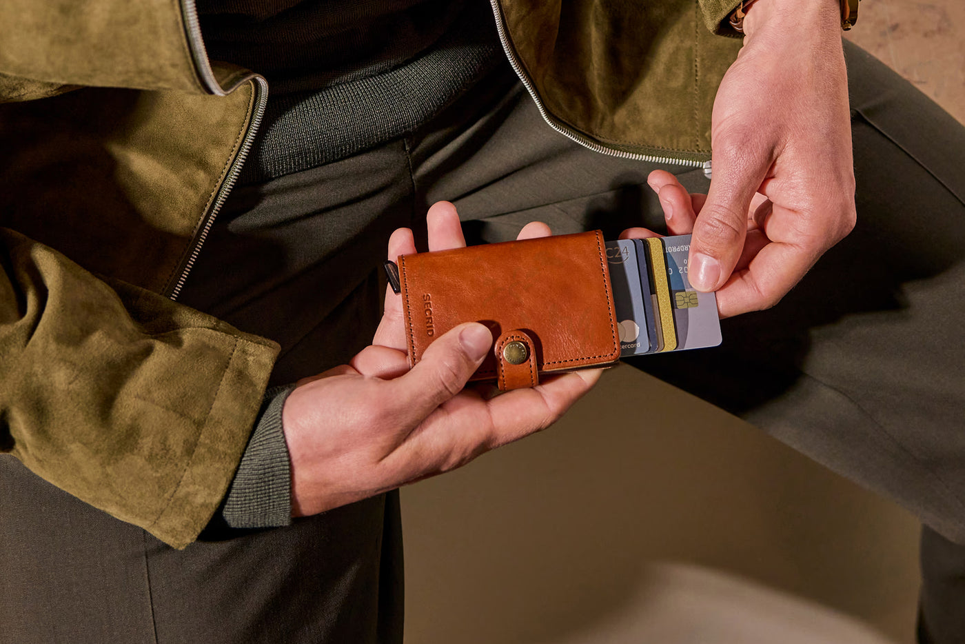 A man holding a brown leather spring wallet
