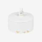 White ceramic jar with gold bird designs on a white background