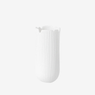 White vase with ribbed texture on a light gray background